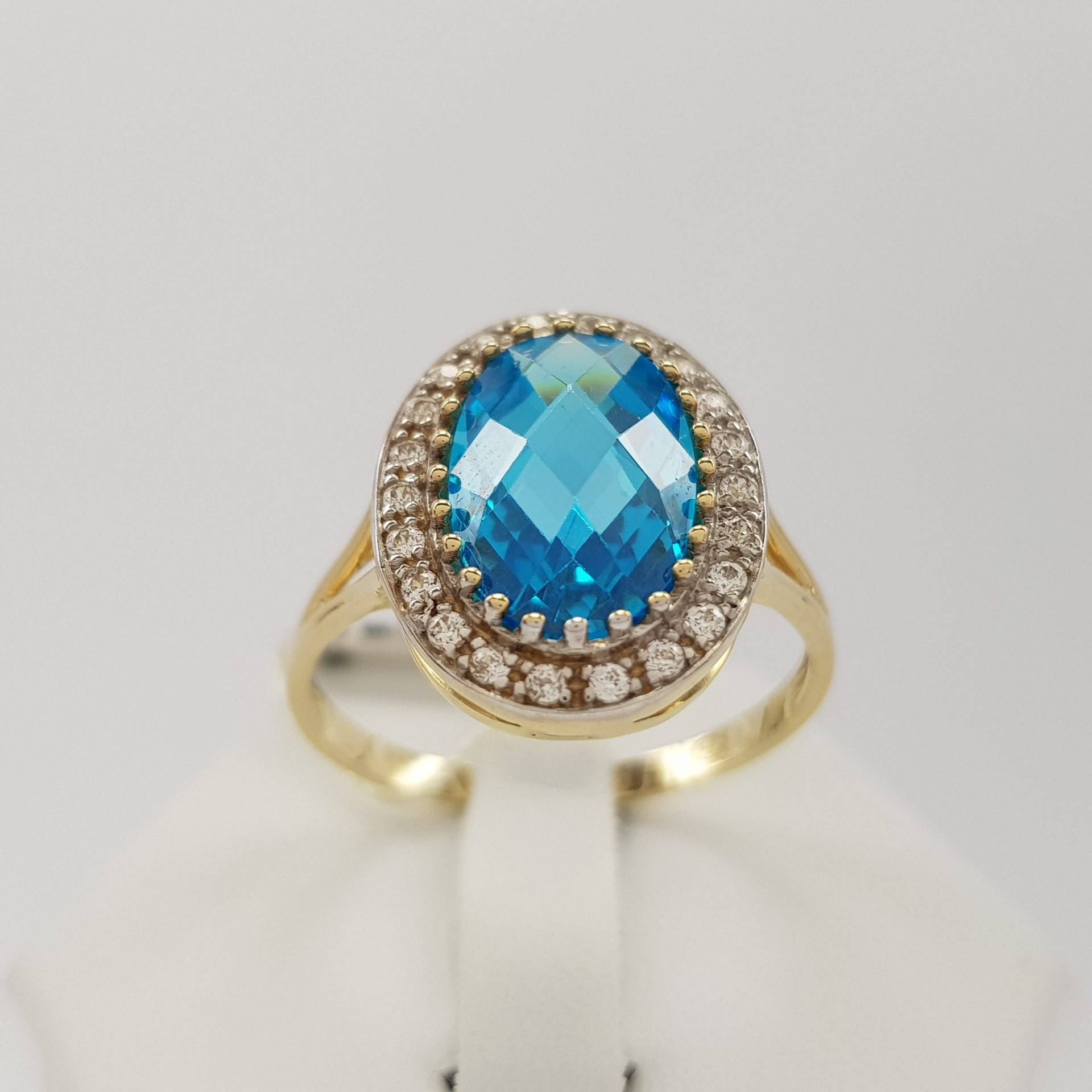 Niepowtarzalny pierścionek złoty z niebieską cyrkonią w fasetowym szlifie